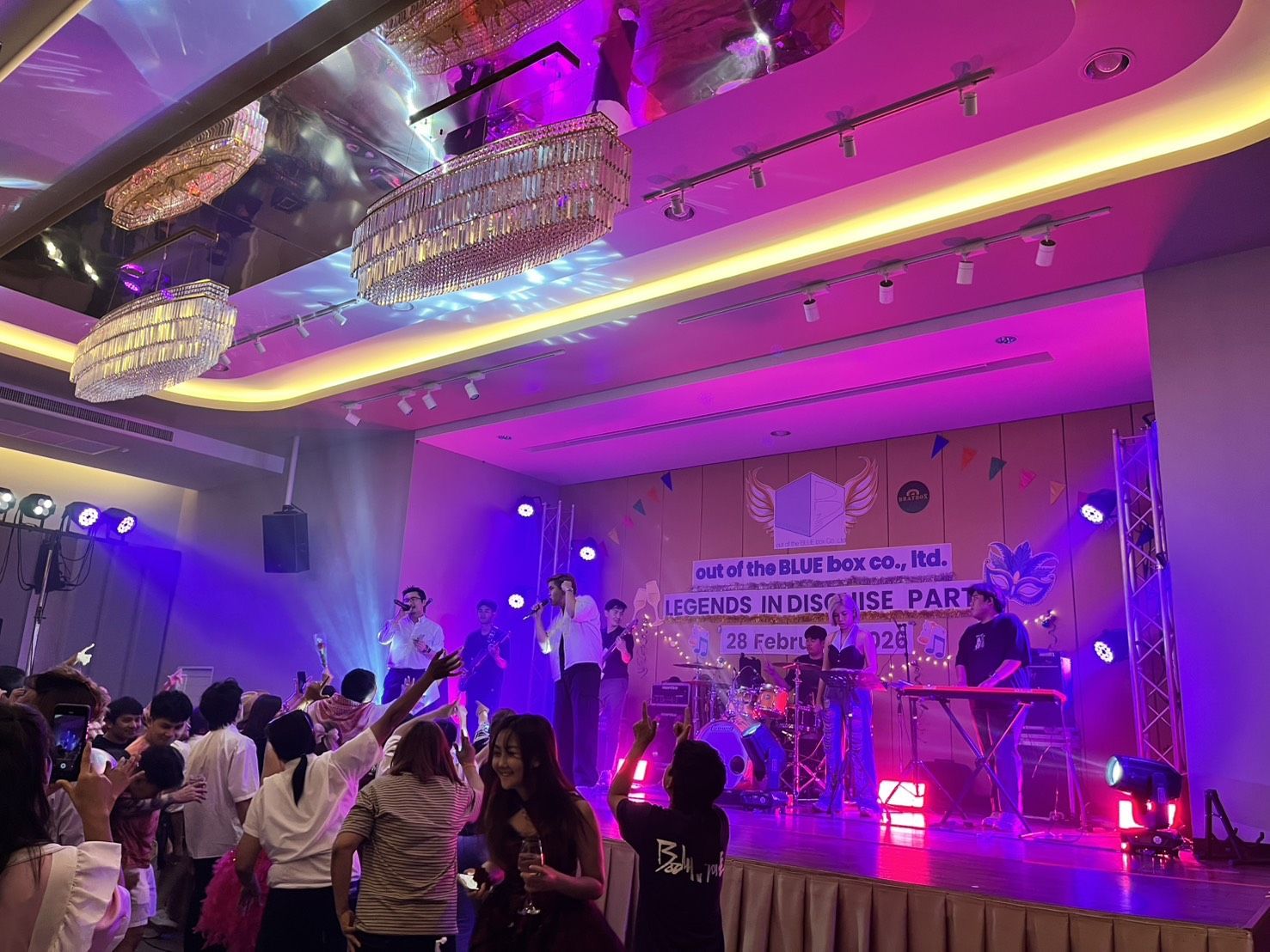 Live band on stage under purple party lighting