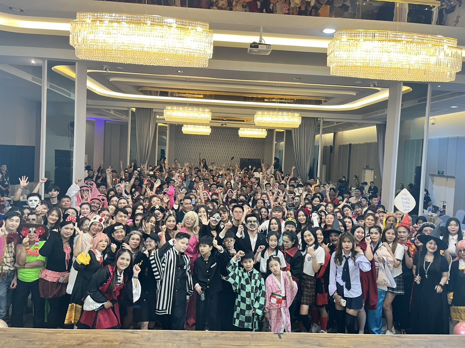 Large group photo of party guests in front of the stage