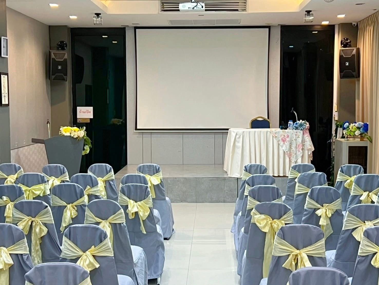 Theatre-style seating facing the stage and projector screen in Norasing 1