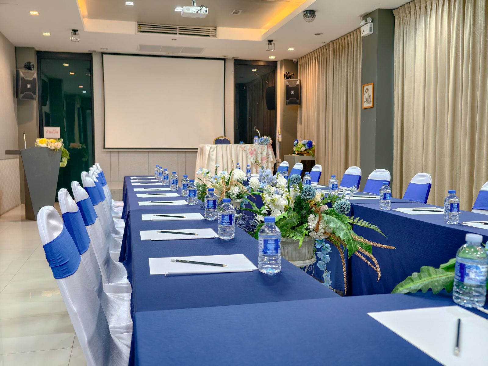Meeting tables laid with notepads, pens and water
