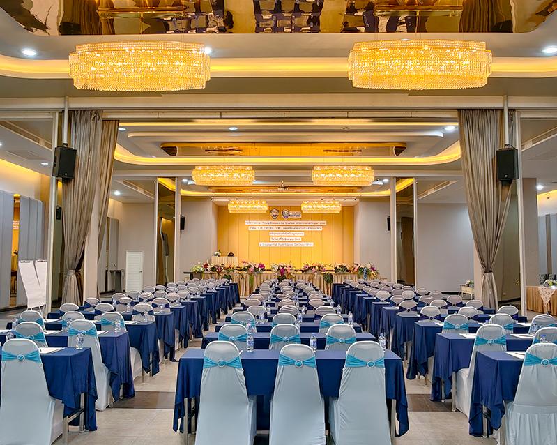 Conference seating facing the stage beneath chandeliers