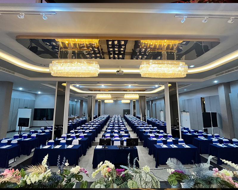 Ballroom set classroom-style with flowers along the stage