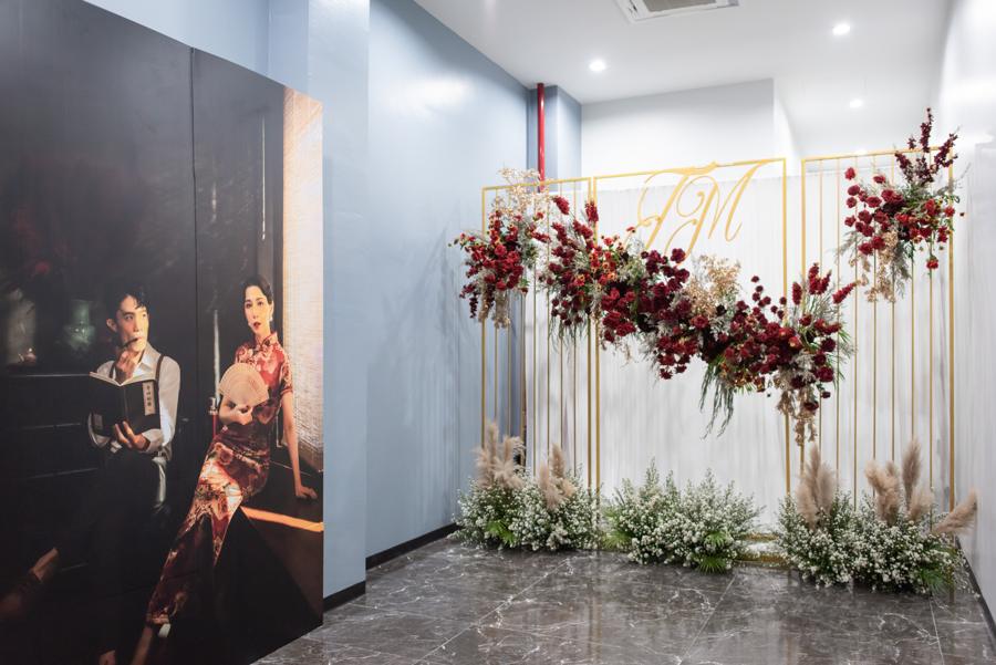 Photo corner with gold frames, red flowers and a portrait of the couple