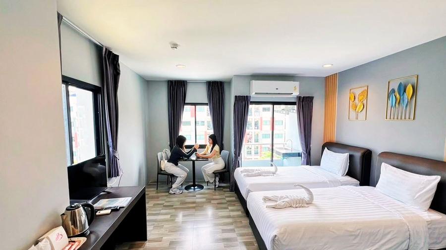 Twin room with two guests at a small table by the window