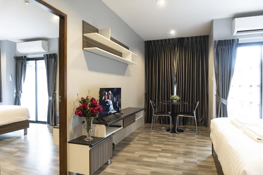 Executive Room living area with TV, dining table and bed