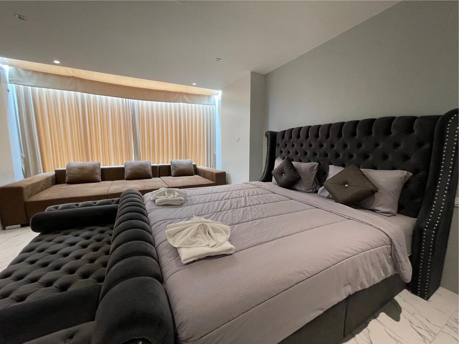 Honeymoon Suite bed with grey linen and lounge sofa