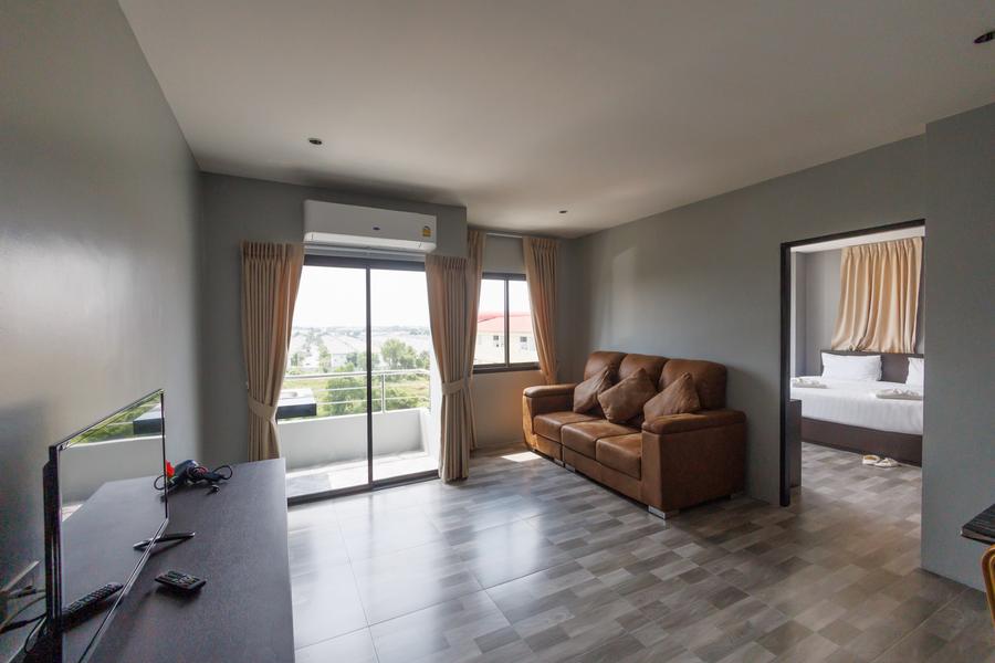 VIP Suite living room with leather sofa and balcony doors