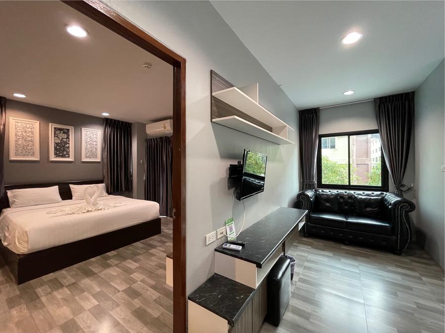 Executive Room bedroom and sitting area with leather sofa