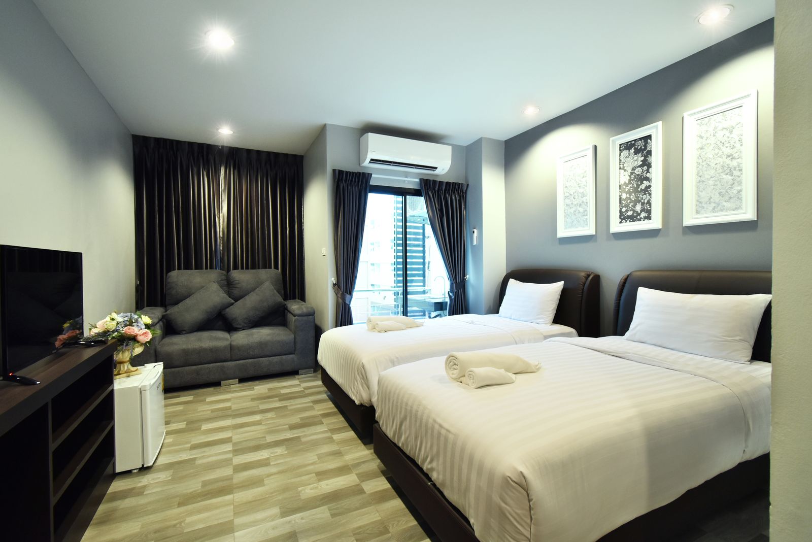 Deluxe room with twin beds, sofa and flat-screen TV