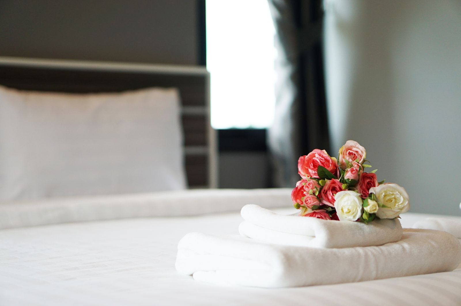 Folded towels and roses on the bed