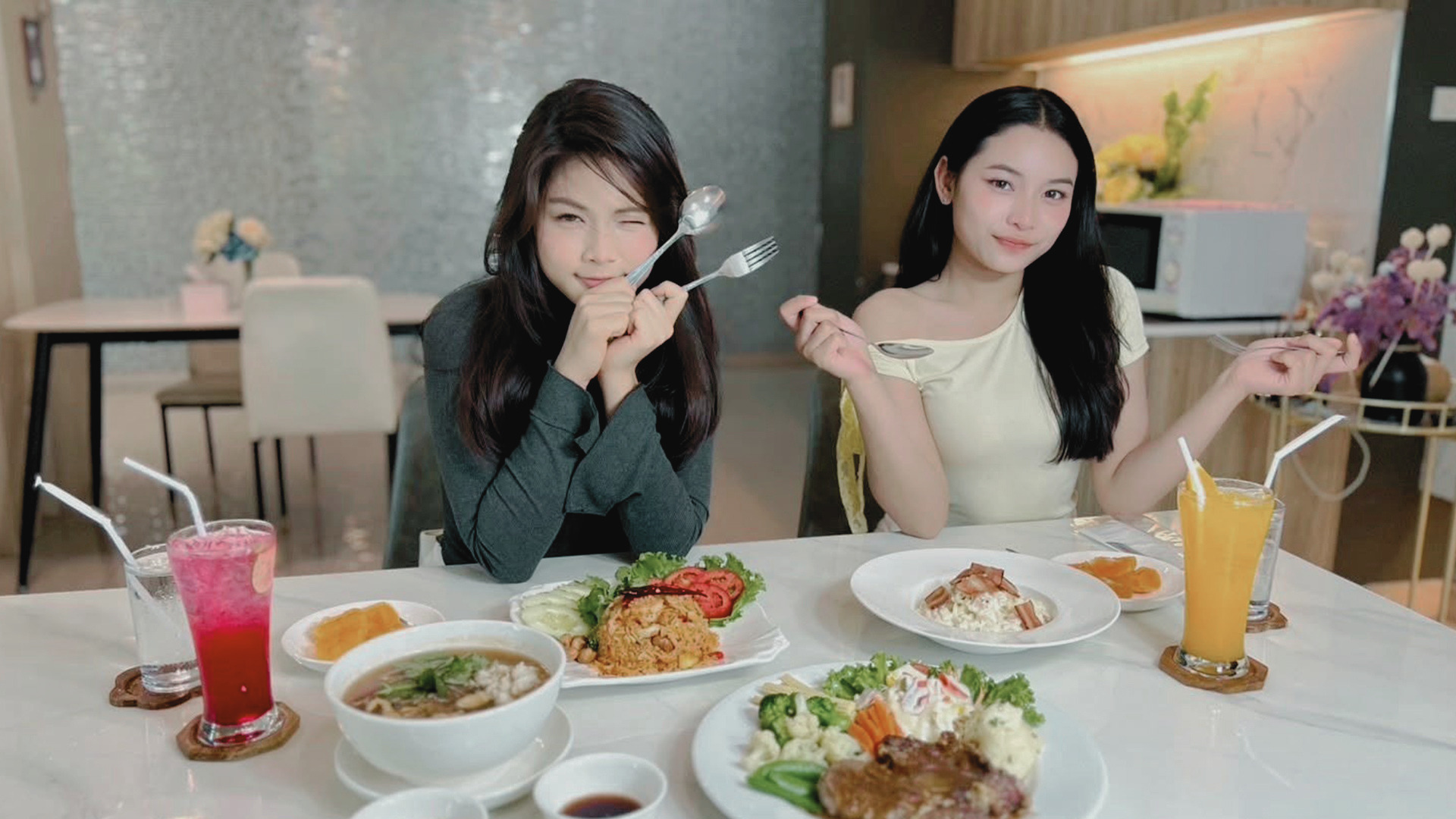 Two guests enjoying Thai and Western dishes with fresh drinks at the hotel restaurant