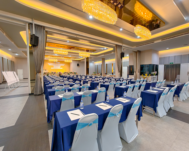 Seminar tables laid with notepads, pens and bottled water for every guest